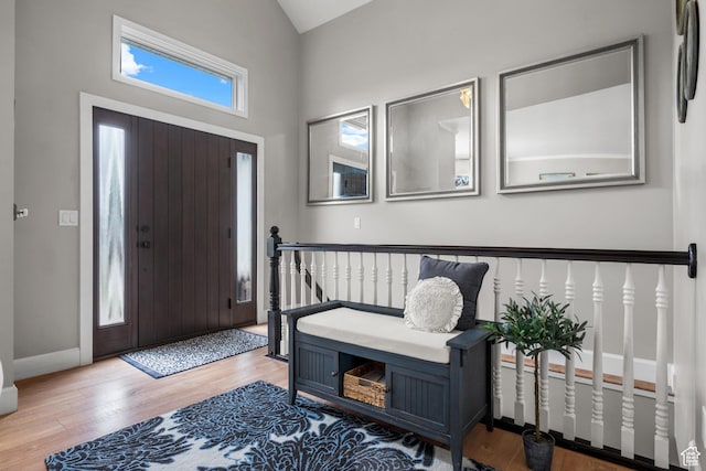 entrance foyer with wood finished floors, vaulted ceiling, and baseboards