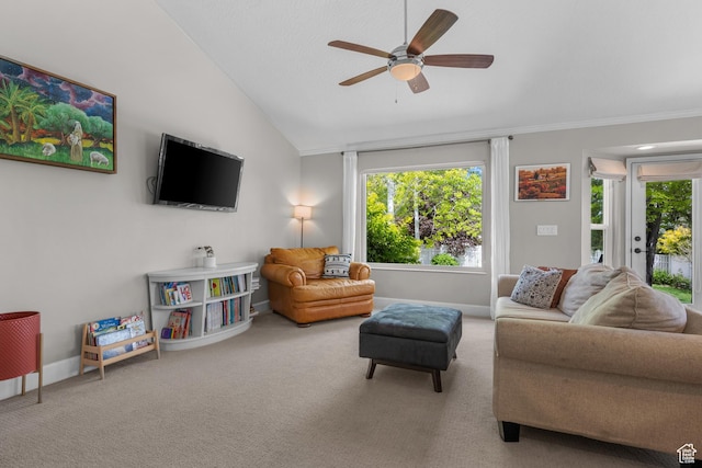 living area with lofted ceiling, carpet flooring, ceiling fan, baseboards, and ornamental molding