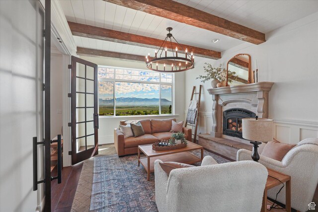 6071 W 1800 S, Mendon, UT 84325 - living area featuring wood finished floors, a fireplace with raised hearth, a chandelier, and beamed ceiling