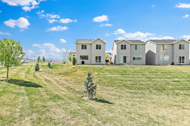 895 S Brubaker Way, Santaquin, UT 84655 - rear view of house featuring stucco siding, a lawn, and a residential view