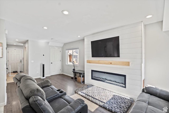 living area with recessed lighting, wood finished floors, a large fireplace, and baseboards