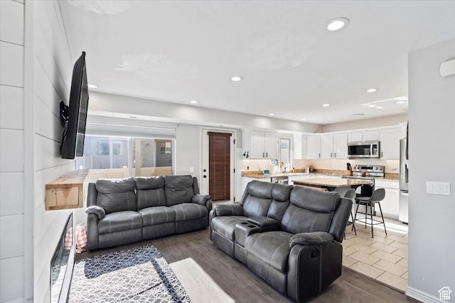living area with recessed lighting and wood finished floors