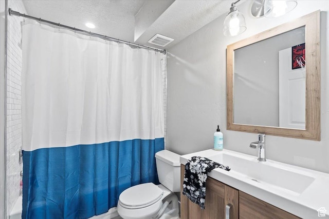 full bath with a textured ceiling, toilet, vanity, and shower / bath combo