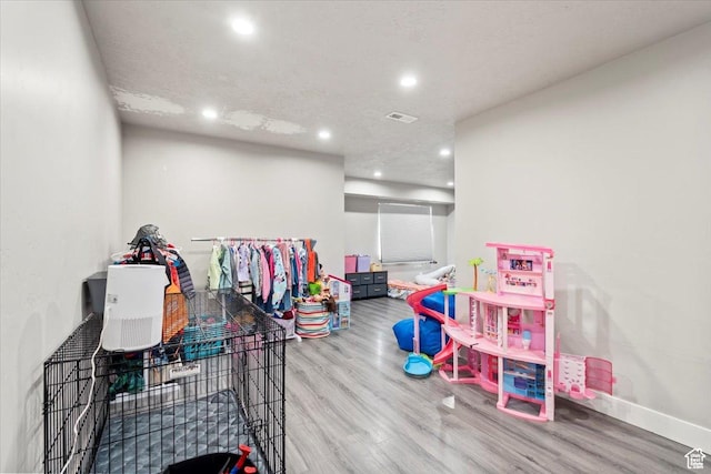 recreation room with wood finished floors, recessed lighting, and baseboards