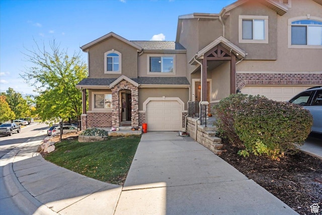 view of front of home with a garage, stucco siding, concrete driveway, and stone siding