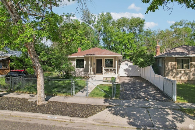 2597 S Elizabeth St, Salt Lake City, UT 84106 - bungalow featuring a gate, covered porch, a fenced front yard, and concrete driveway