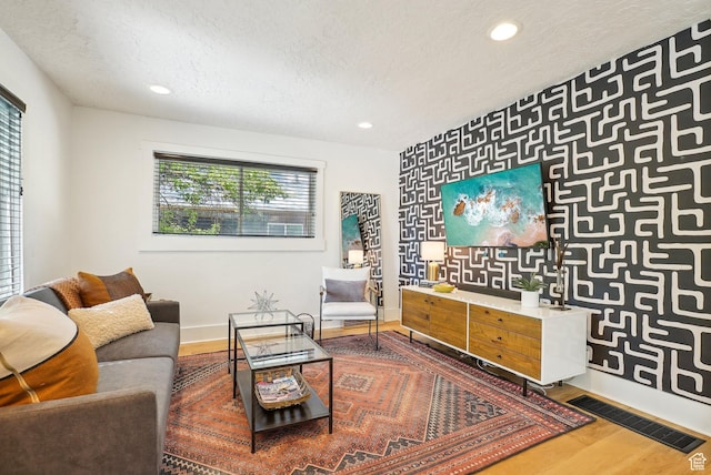 2597 S Elizabeth St, Salt Lake City, UT 84106 - living room with baseboards, a textured ceiling, wood finished floors, recessed lighting, and an accent wall