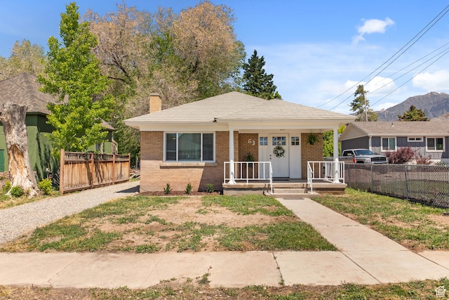 63 E 100 S, Nephi, UT 84648 - bungalow-style home featuring brick siding, a porch, a chimney, and fence