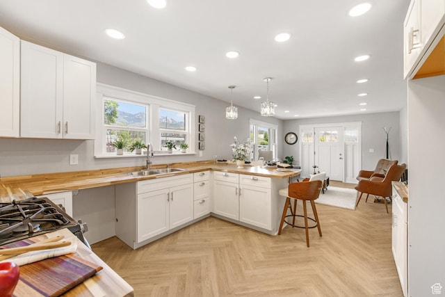 63 E 100 S, Nephi, UT 84648 - kitchen featuring a sink, wood counters, a peninsula, recessed lighting, and white cabinets