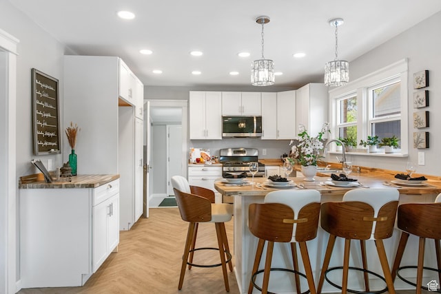 63 E 100 S, Nephi, UT 84648 - kitchen with stainless steel appliances, a kitchen breakfast bar, recessed lighting, pendant lighting, and white cabinets