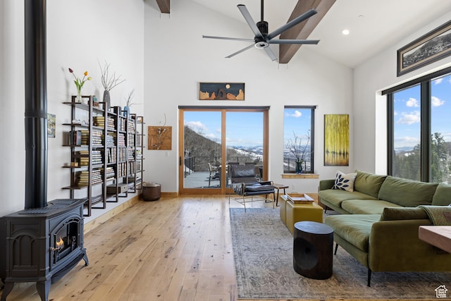 10256 N Basin Canyon Rd, Park City, UT 84098 - living room featuring high vaulted ceiling, a ceiling fan, light wood-style flooring, a wood stove, and baseboards