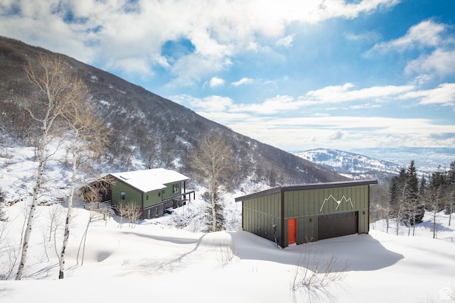 10256 N Basin Canyon Rd, Park City, UT 84098 - view of snow covered exterior with a garage, board and batten siding, a mountain view, and an outdoor structure