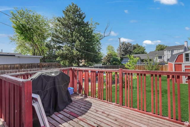 wooden terrace with a storage unit and an outbuilding
