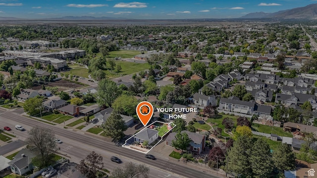 aerial view of property and surrounding area featuring mountains, property parcel outlined, and nearby suburban area