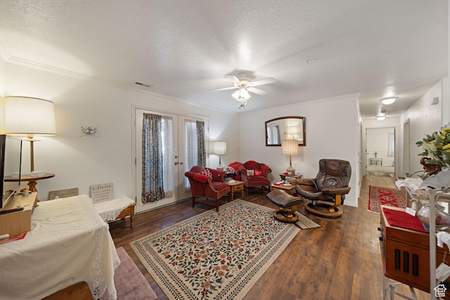 living area featuring wood finished floors, a ceiling fan, ornamental molding, french doors, and a textured ceiling