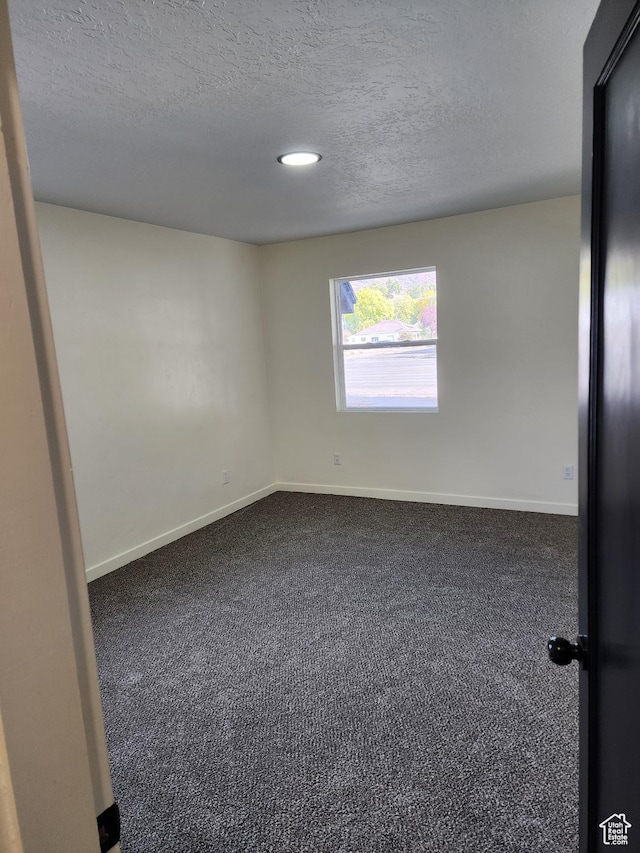 spare room featuring dark carpet, baseboards, a textured ceiling, and recessed lighting