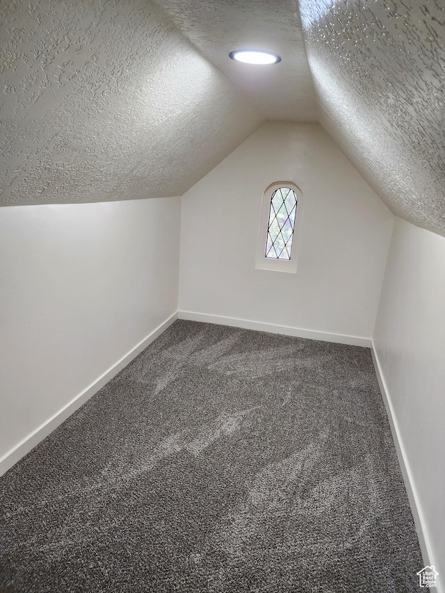 bonus room with a textured ceiling, baseboards, carpet floors, and lofted ceiling