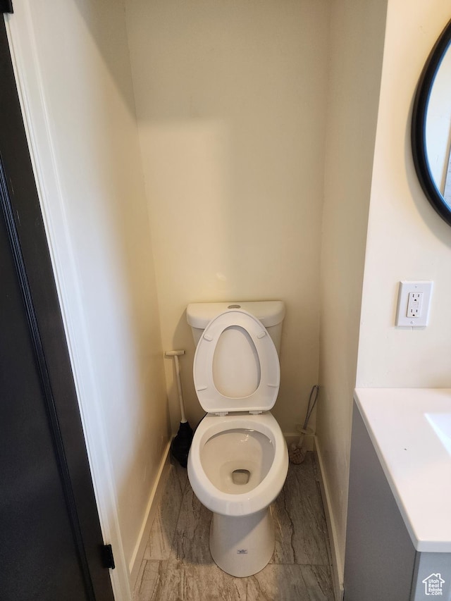 bathroom with baseboards, toilet, and marble finish floors