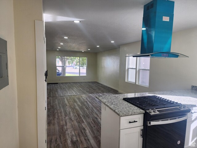 kitchen with gas range oven, island range hood, dark wood-style flooring, recessed lighting, and white cabinetry