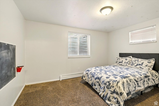 carpeted bedroom featuring a baseboard heating unit and baseboards