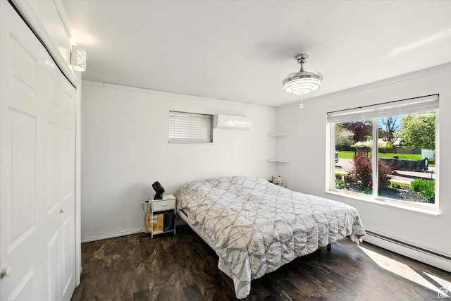 bedroom with a baseboard heating unit, a closet, crown molding, and an AC wall unit