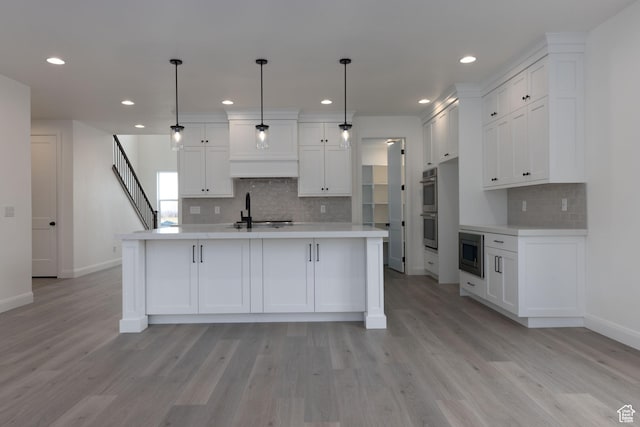 kitchen featuring stainless steel appliances, baseboards, light countertops, backsplash, and light wood-style flooring