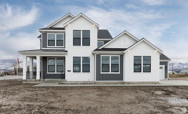 view of front of house featuring covered porch, a standing seam roof, board and batten siding, and a shingled roof