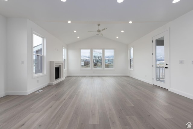 unfurnished living room featuring a ceiling fan, light wood-style flooring, lofted ceiling, a fireplace, and recessed lighting