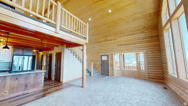 1982 S High Juniper Dr, Cedar City, UT 84720 - unfurnished living room with rustic walls, a towering ceiling, stairway, wooden ceiling, and recessed lighting