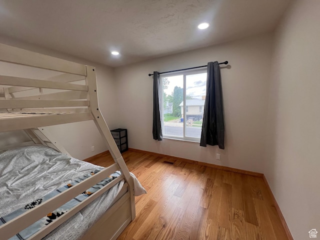 bedroom with light wood-style floors, baseboards, and recessed lighting