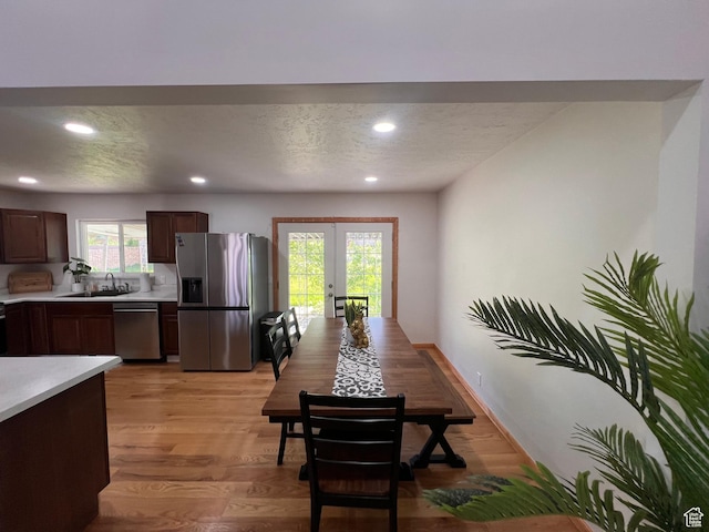 dining area featuring french doors, a textured ceiling, recessed lighting, light wood-style floors, and baseboards