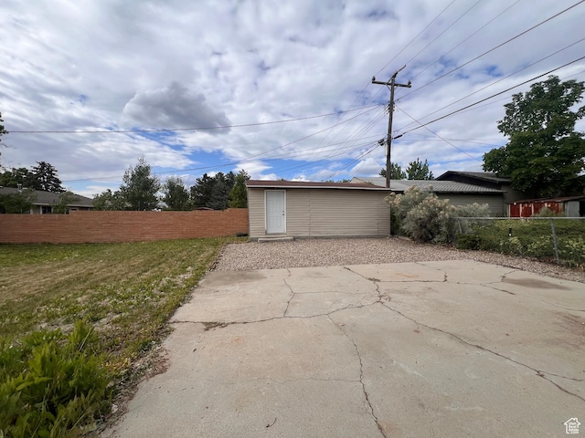 view of patio featuring fence and an outbuilding