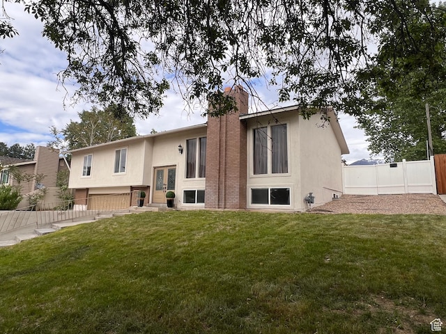 rear view of house featuring stucco siding, a chimney, entry steps, and french doors