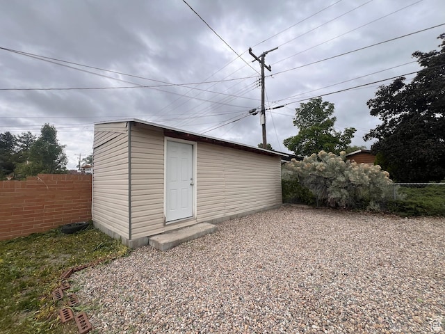 view of outbuilding with fence and an outbuilding