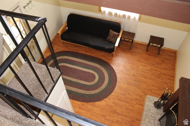 sitting room featuring wood finished floors, baseboards, and an upstairs landing