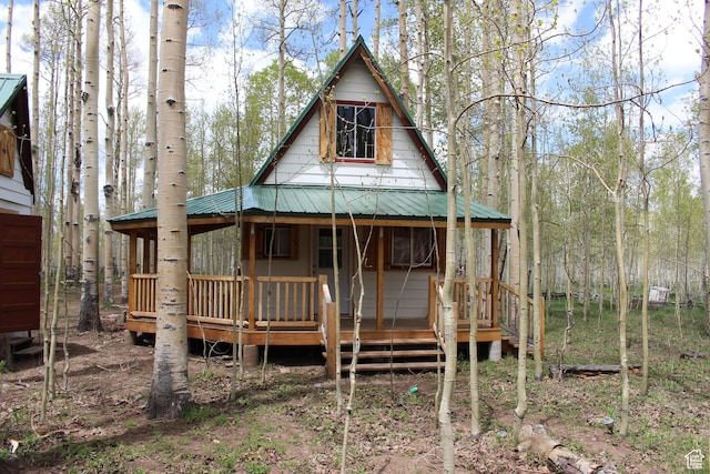 back of house with metal roof and a porch