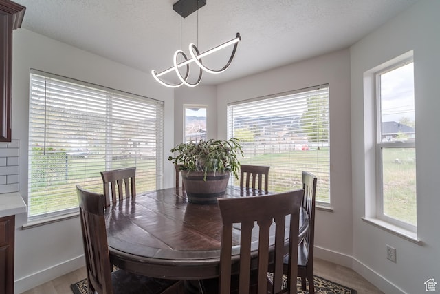 320 E 100 N, Manti, UT 84642 - dining space featuring baseboards, light wood-style floors, a chandelier, and a textured ceiling