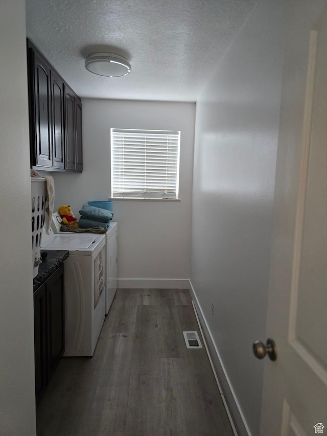 laundry area featuring independent washer and dryer, cabinet space, light wood finished floors, a textured ceiling, and baseboards