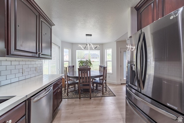 320 E 100 N, Manti, UT 84642 - kitchen with stainless steel appliances, a chandelier, backsplash, light wood finished floors, and light countertops