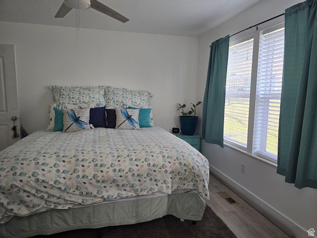 bedroom featuring wood finished floors, baseboards, and ceiling fan