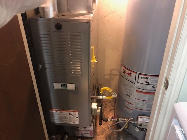 utility room with water heater and heating unit