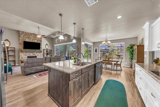 kitchen featuring a sink, stainless steel dishwasher, light wood-style flooring, white cabinets, and dark brown cabinetry