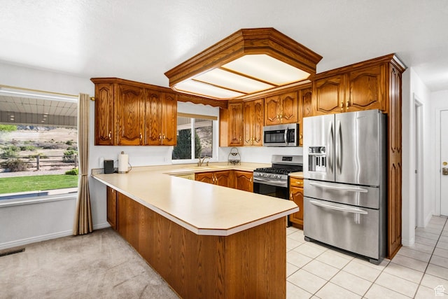 860 S 720 W, Glenwood, UT 84730 - kitchen with stainless steel appliances, a sink, a peninsula, light countertops, and brown cabinets