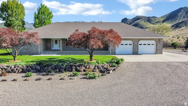 860 S 720 W, Glenwood, UT 84730 - view of front facade featuring an attached garage, driveway, brick siding, a front lawn, and a mountain view