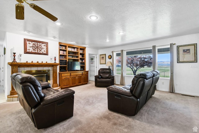 860 S 720 W, Glenwood, UT 84730 - living room featuring light carpet, a ceiling fan, a textured ceiling, a tiled fireplace, and recessed lighting