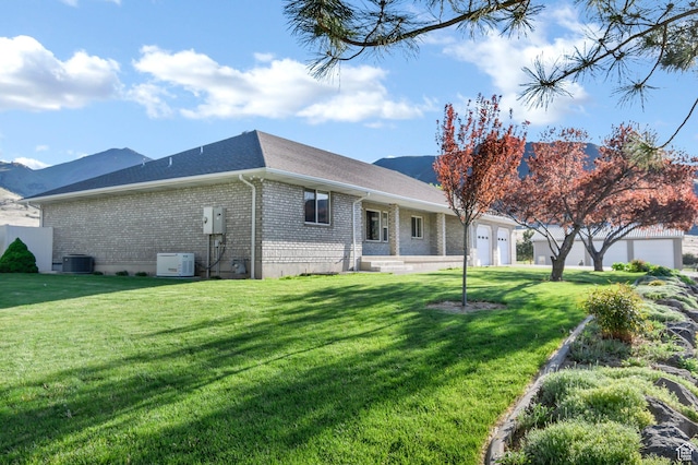 860 S 720 W, Glenwood, UT 84730 - back of property featuring cooling unit, brick siding, an attached garage, a yard, and a shingled roof