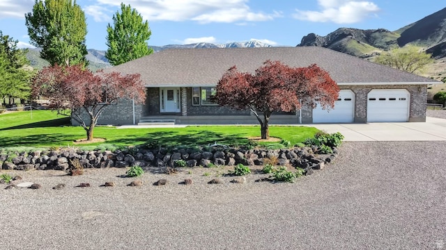 860 S 720 W, Glenwood, UT 84730 - view of front of home featuring a garage, brick siding, driveway, a front yard, and a mountain view