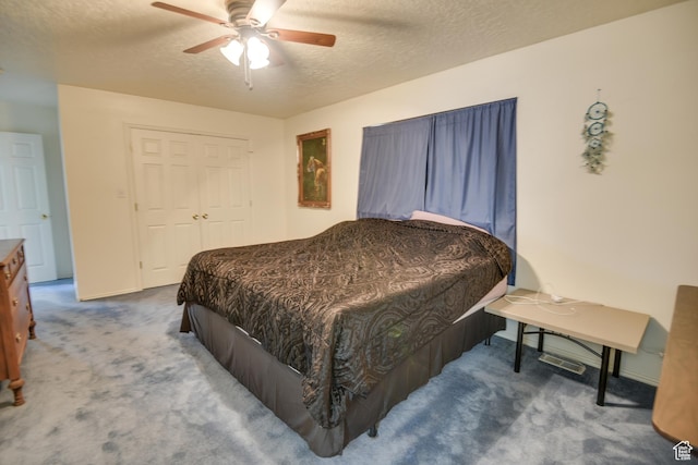 carpeted bedroom with a textured ceiling, ceiling fan, baseboards, and a closet
