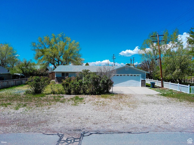 view of front facade featuring fence, a garage, and concrete driveway
