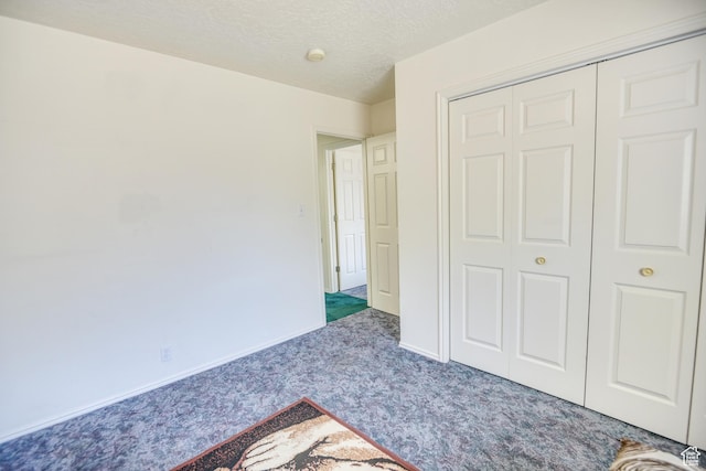 unfurnished bedroom with carpet floors, a closet, and a textured ceiling